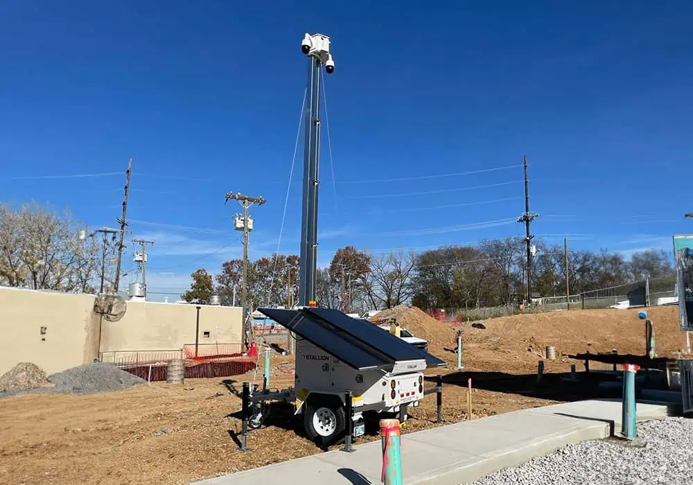 Mobile surveillance trailer with solar security cameras secures construction site for commercial and parking lot security.
