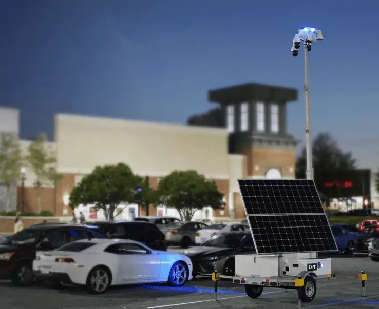 A mobile surveillance trailer with solar security cameras provides parking lot security for commercial properties.