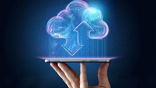 A hand holds a smartphone with cloud sync icons, representing mobile surveillance trailer and solar security camera systems.