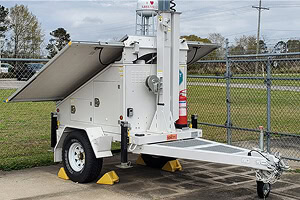 Mobile surveillance trailer with solar security camera, stabilizers, and fire extinguisher, ideal for commercial parking lot security.