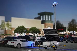 A mobile surveillance trailer with solar security camera provides parking lot security near commercial centers.