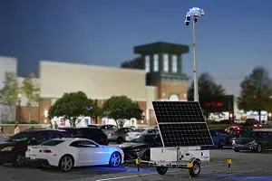 A mobile surveillance trailer with solar security camera provides parking lot security near commercial centers.